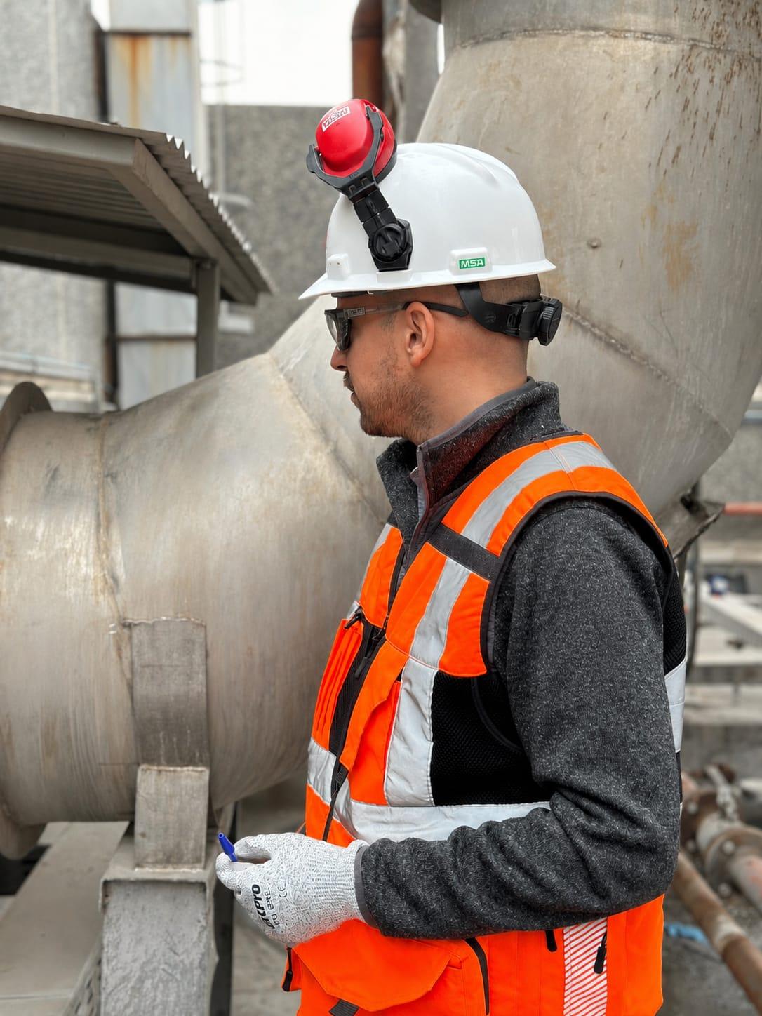 Sebastián Balut inspeccionando ductos en planta, con equipo de protección personal